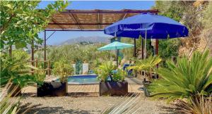 a swimming pool with two umbrellas and a swimming pool at La Casa Turquesa in Frigiliana
