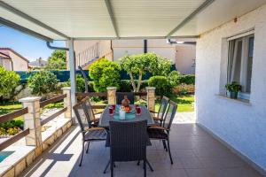a patio with a table and chairs on a porch at Pool Apartments Franko - Shared Pool in Ližnjan