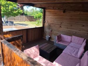 a patio with a couch and chairs on a deck at Le Chêne Vert - Grande Villa familiale avec piscine - Bassin d'Arcachon in Arès