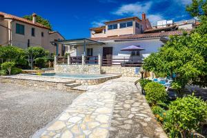 a house with a swimming pool in a yard at Pool Apartments Franko - Shared Pool in Ližnjan