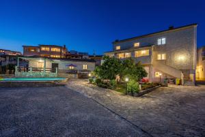 a large building with a pool in front of it at Pool Apartments Franko - Shared Pool in Ližnjan
