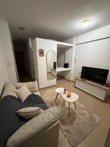a living room with a couch and a tv and a table at Depto Céntrico cq in Bahía Blanca
