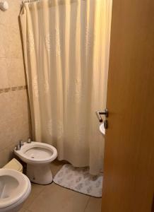 a bathroom with a white shower curtain and a toilet at Depto Céntrico cq in Bahía Blanca