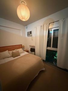 a bedroom with a large bed and a window at Depto Céntrico cq in Bahía Blanca