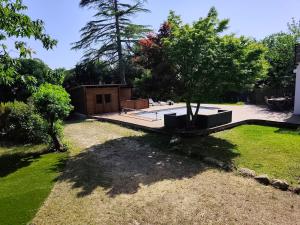 a yard with a tree and a house at Le Chêne Vert - Grande Villa familiale avec piscine - Bassin d'Arcachon in Arès