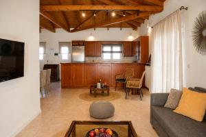 a living room and kitchen with a couch and a table at Niobe Luxury Residence in Loutraki