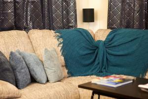 a brown couch with pillows on it with a table at An-Garo Ko-Zy Spaces in Saint Johnʼs