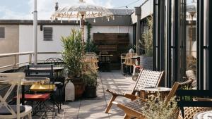 eine Terrasse mit Tischen und Stühlen auf einem Balkon in der Unterkunft Ruby Claire Hotel Geneva by IHG in Genf