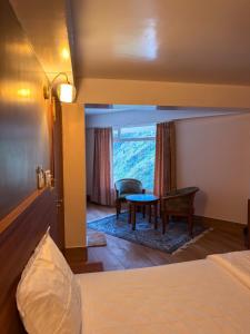 a bedroom with a bed and a table in a room at The Pham Inn in Bomdila
