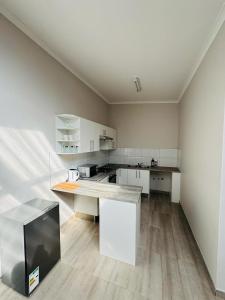 a large kitchen with white cabinets and a counter at Gottys Lagoon Stay in Walvis Bay