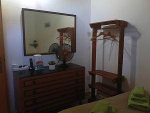 a bedroom with a dresser with a mirror and a fan at Lo chalet del vicolo in Roccasecca dei Volsci +8 photos