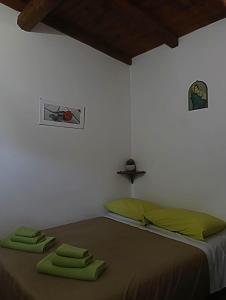 a bedroom with a bed with green towels on it at Lo chalet del vicolo in Roccasecca dei Volsci
