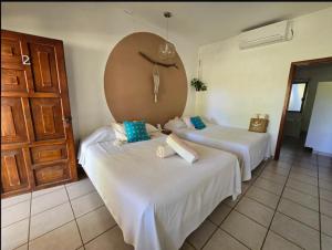 a room with two beds and a door at Eco Taboutique Hotel & Cabañas in Monte Gordo