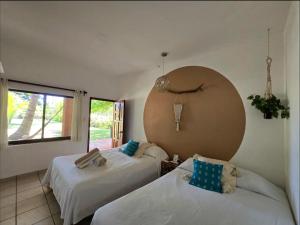 a bedroom with two beds and a large window at Eco Taboutique Hotel & Cabañas in Monte Gordo