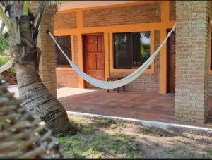 a hammock hanging from a porch of a house at Eco Taboutique Hotel & Cabañas in Monte Gordo