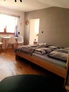 a bedroom with a bed with a table and a dining room at Chatka Czesia in Sosnówka
