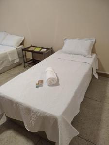 a large white bed with a white blanket on it at Loft Campinho 3 in Estação Inhoaíba