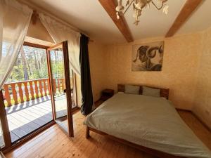 a bedroom with a bed and a balcony at Brižių sodyba in Brižiai +54 photos