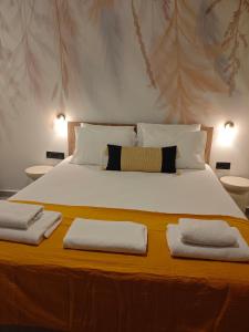 a bedroom with a large bed with two towels on it at Aggeliki Apartment in Skiathos +3 photos