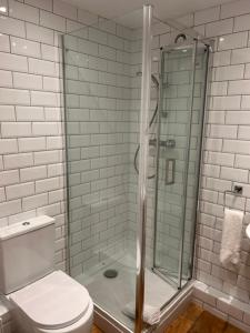 a bathroom with a toilet and a glass shower at Ganton Greyhound Hotel in Ganton +62 photos
