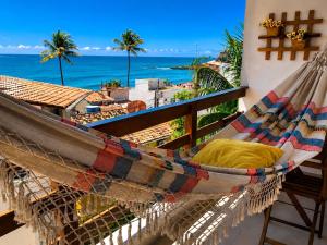 a hammock on a balcony with a view of the ocean at Flats Morro de São Paulo in Morro de São Paulo
