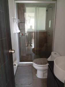 a bathroom with a toilet and a glass shower at Habibi Cocoyoc in Cocoyoc
