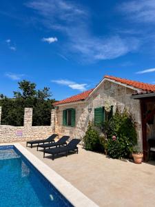 a house with a swimming pool next to a building at Villa Olive in Dol