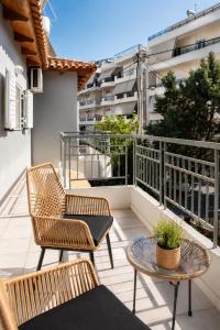 a balcony with two chairs and a table at Niobe Luxury Residence in Loutraki