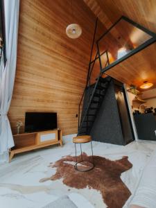 a living room with a staircase and a chair at Cabana dos Colibris in Santa Teresa