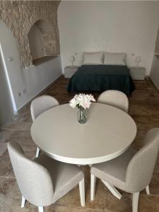 a white dining room table with chairs and a bed at Dimora Mavi' in Noci +9 photos