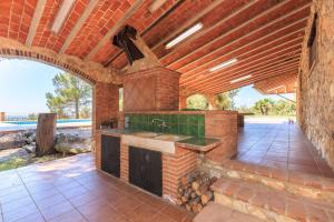 an outdoor kitchen with a brick wall at Masia Garriga in Tarragona