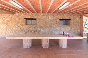 a wooden table in a room with a stone wall at Masia Garriga in Tarragona +95 photos