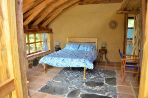 a bedroom with a bed in the corner of a room at Chalet Casa de Teja in Tinjacá +38 photos