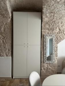 a white cabinet in a room with a mirror at Dimora Mavi' in Noci