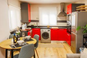 a kitchen with red cabinets and a table and a washing machine at Apartamento en Villamediana-Logroño tranquilo y bien equipado in Villamediana de Iregua +14 photos
