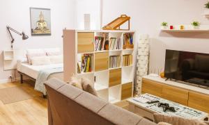 a living room with a book shelf and a television at Apartamento en Villamediana-Logroño tranquilo y bien equipado in Villamediana de Iregua