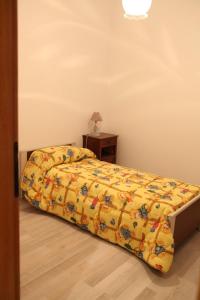 a bedroom with a bed with a yellow comforter and a table at la casa nell'acropoli , primo piano in Arpino +8 photos