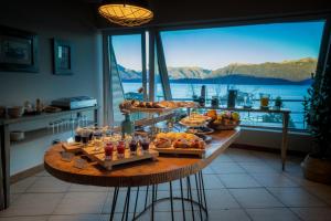 a buffet of food on a table with a view of the water at Sol Arrayan Hotel & Spa in Villa La Angostura