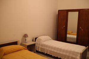a bedroom with two beds and a mirror at la casa nell'acropoli , primo piano in Arpino