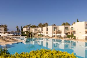 a swimming pool at a resort with chairs and umbrellas at Electra Beach Holiday Village in Ayia Napa