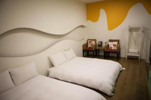 台東市的住宿－星光民宿，一间卧室配有两张床和两把椅子