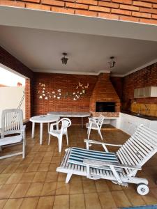 a patio with a table and chairs and a brick wall at Quarto triplo - Casa Azul - Águas de São Pedro in Águas de São Pedro