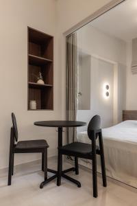 a bedroom with a table and two chairs and a bed at Sola District Volos in Volos
