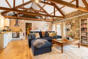 a living room with a blue couch and a table at Shippon in Michaelstow
