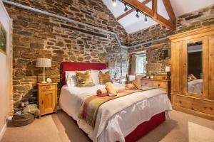 a bedroom with a large bed in a brick wall at Shippon in Michaelstow