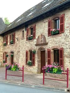 a stone building with flowers in front of it at Relais du Moulin - Bed & Breakfast in Abreschviller
