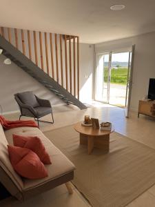a living room with a couch and a table at Cosy Appartement avec Parking in Feugarolles