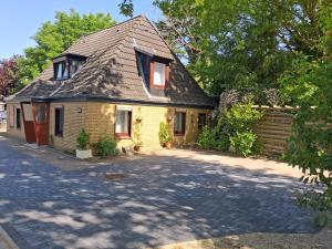 a yellow brick house with a shingled roof at Gemütliche Monteurunterkunft bei Lübeck in Stockelsdorf