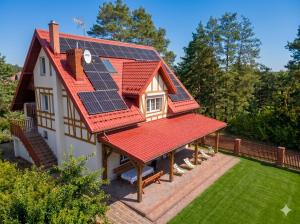 a house with solar panels on its roof at Mazury Villa Ecomfort in Szeligi