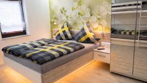 a bedroom with a bed with yellow and black pillows at Hotel Garni Silberburg - Schwarzwald-Plus Karte in Bad Wildbad